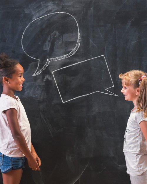 Two students drawing at a chalkboard